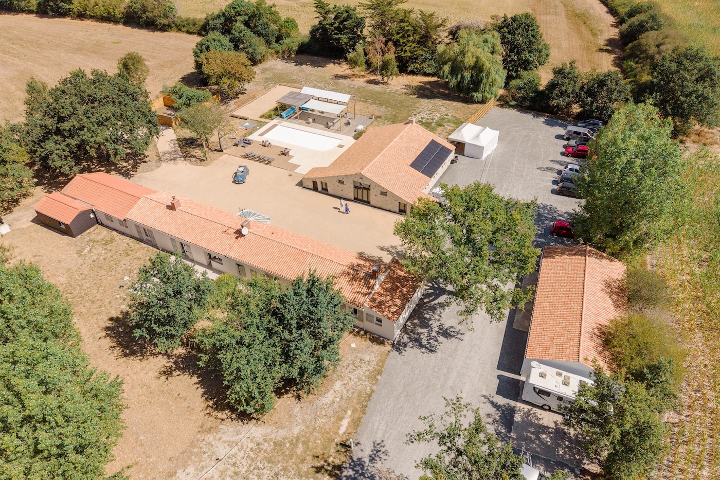 Vue aérienne du Domaine du Chêne Vert à Sallertaine, gîte et salle de mariage entourés de champs dans le Marais vendéen