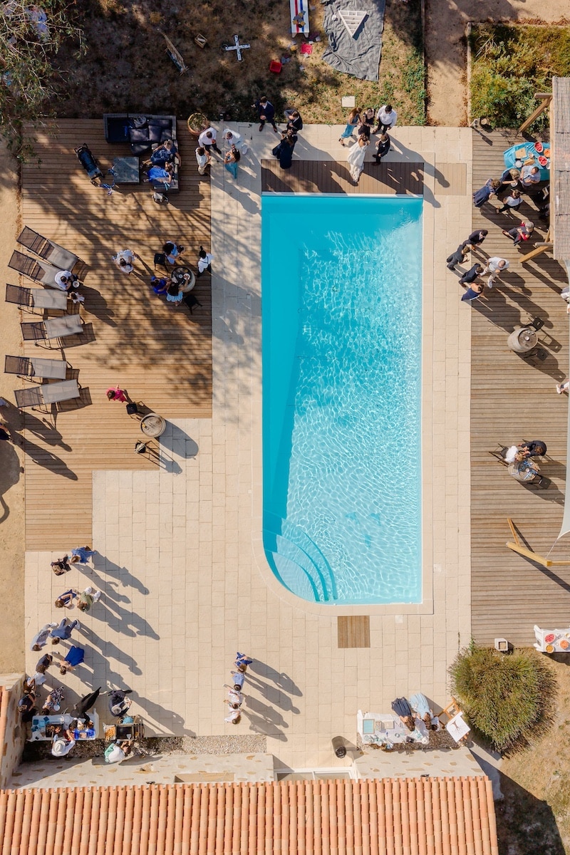 Vue aérienne de la piscine du Domaine du Chêne Vert à Sallertaine, invités d'un mariage sur la terrasse en bois, gîte de groupe en Vendée Vue aérienne de la piscine du Domaine du Chêne Vert à Sallertaine, invités d'un mariage sur la terrasse en bois, gîte de groupe en Vendée